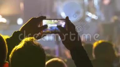 音乐摇滚音乐会上的人用智能手机拍照或录制视频
