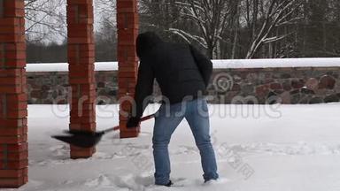 年轻人在冬天用雪铲