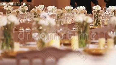 餐桌上摆着一排排酒杯和一<strong>朵朵</strong>白花