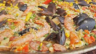 西班牙海鲜饭和<strong>黄米</strong>饭，虾和贻贝在食品市场上烹饪。 放大摄像机。 街头美食节