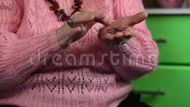 一位身穿粉色套头衫的老年妇女数着<strong>零钱</strong>