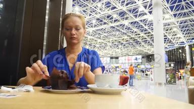 女士在机场<strong>候机</strong>室使用智能手机。 她喝咖啡。 对机场飞行的期望。 4k，慢动作