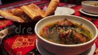 餐厅提供美味的阿塞拜疆国民<strong>羊肉汤</strong>。 面包背景上白色盘子里的肉