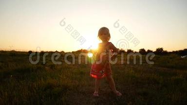 那个女孩在夕阳的光线下在田野里旋转。
