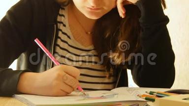 年轻的女人拿着铅笔在家画画。 为成人和儿童着色。 为了缓解压力。 成人着色书