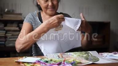 老年妇女在白棉布上缝制十字绣图片. 4K，慢动作。