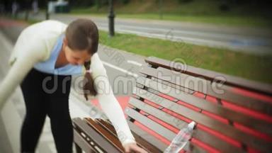 一个小胖女孩在滚筒上<strong>喝水</strong>。 一个孩子在长凳上的公园里<strong>喝水</strong>