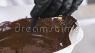 把糖果浸在融化的巧克力里。巧克力糖果的生产。