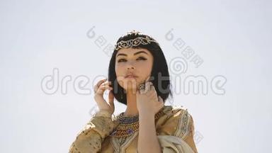美丽的女人，有着时尚的妆容和发型，像埃及女王克利奥帕特拉在户外<strong>抵御</strong>沙漠大风天气