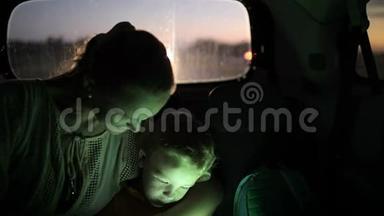 妈妈和儿子晚上在车里用触摸板