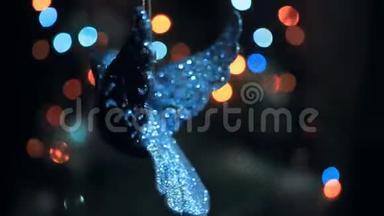 一个闪闪发光的圣诞装饰，<strong>为</strong>一棵圣诞树的形状，一只鸟在花环的灯光下旋转