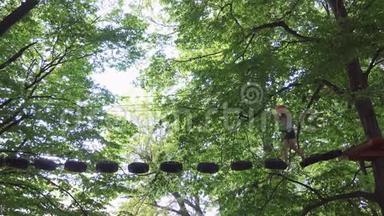 一个人走在一个绳索公园的悬索小路上