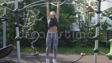 运动女孩正在公园里拉起<strong>运动器材</strong>