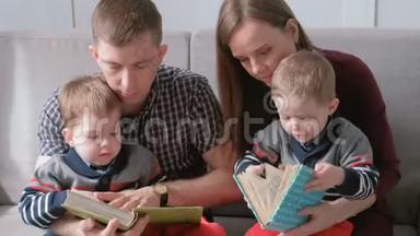 一家人的和两个双胞胎兄弟坐在沙发上看书。 家庭阅读时间。