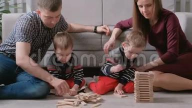 一家人的妈妈、爸爸和两个<strong>双胞胎兄弟</strong>一起在地板上用木块做游戏。