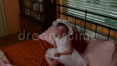 一个可爱的小女孩<strong>坐在床上</strong>微笑。 父母卧室和女儿在<strong>床上</strong>。 一个小女孩