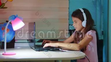 小<strong>女孩</strong>带着耳机在笔记本电脑上玩<strong>网络</strong>游戏。 电脑上的小<strong>女孩</strong>在<strong>社交</strong>媒体上留言