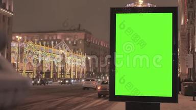 一个大广告牌，街道上有一个绿色的屏幕，为节日装饰。