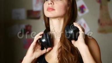 迷人的年轻女子戴着耳机听音乐<strong>播放器</strong>上的音乐