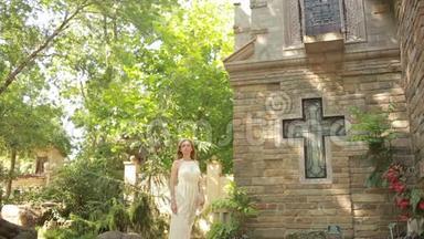 穿着白色裙子的女孩在哥特式教堂散步。 旅游景点