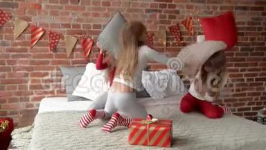 穿着睡衣的三胞姐妹用枕头安排了打斗。 卧室装饰着圣诞花环和圣诞节