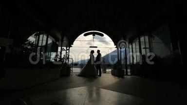 婚礼夫妇在宫殿里接吻的剪影。 意大利科莫