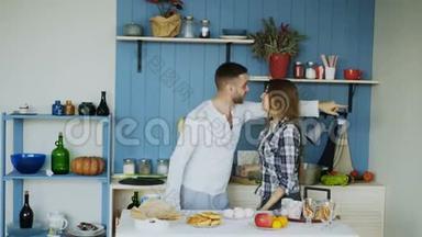 年轻快乐的一对夫妇在家里的厨房里摆好<strong>桌子</strong>吃<strong>早餐</strong>，一边跳舞唱歌，玩得很开心