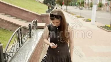 <strong>天气晴朗</strong>的时候，女孩在街上用智能手机发短信