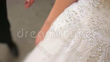新婚快乐的年轻新娘和新郎。 新郎温柔地亲吻美丽的金发新娘的手。 阳光利沃夫