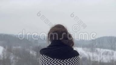 年轻的黑发<strong>女孩</strong>看冬天的山，后景。