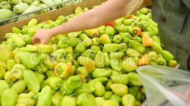 一个女人在<strong>蔬菜货架</strong>上的超市里买<strong>蔬菜</strong>和水果。 男人选择胡椒保加利亚。 慢动作，4k