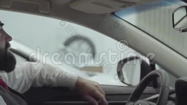 肖像画吸引人的成功胡须男坐在车里，检查从车里买的新车