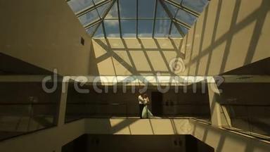 在黑暗的高科技大楼里，可爱的新婚夫妇拥抱在阳台上的剪影