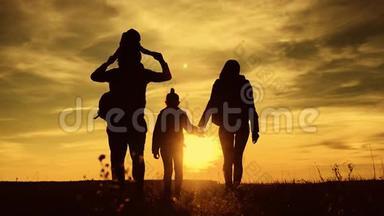 父亲、母亲和孩子徒步旅行的剪影。 婴儿坐在父亲的肩膀上。 徒步旅行背包旅行者徒步旅行