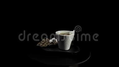 在黑色背景上有咖啡杯的彩色盘子上有<strong>一颗</strong>乌黑的心。