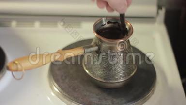 在电炉上煮咖啡，用勺子搅拌