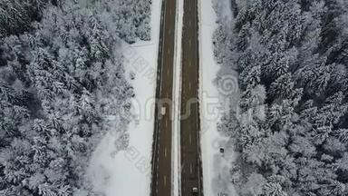4K. 在冰冻的冬季森林里驾驶汽车飞越公路。 空中全景。 消失的角度