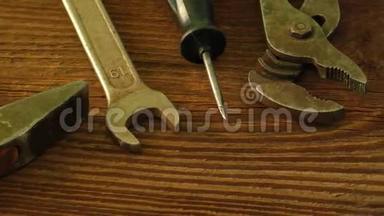 一套木制表面的旧工具：锤子、钳子、扳手、螺丝刀、剪刀