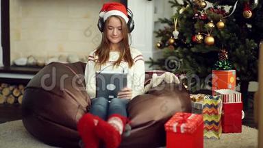 穿着明亮的圣诞袜用垫子听音乐的漂亮女孩
