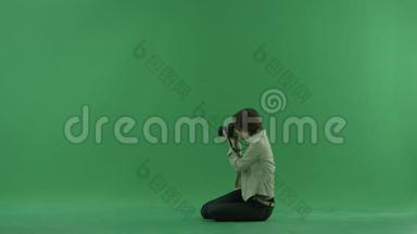 坐着的年轻女子正在绿色屏幕上<strong>左手</strong>边拍照
