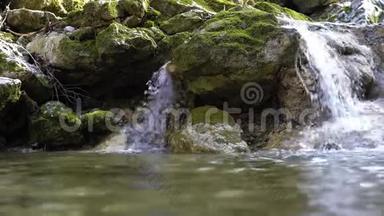 小山河上的瀑布，急流在长满青苔的石质河床中流淌。 春天纯净的淡水