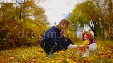 秋天，当黄叶绕着<strong>妈妈</strong>和女孩玩枫叶时，笑着笑着。 <strong>妈妈</strong>拥<strong>抱</strong>和玩耍