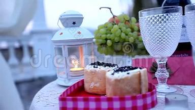浪漫烛光晚餐的装饰。 蜡烛、灯笼、蛋糕和水果作为两人浪漫晚餐