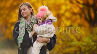 秋天，当黄叶绕着<strong>妈妈</strong>和女孩玩枫叶时，笑着笑着。 <strong>妈妈</strong>拥<strong>抱</strong>和玩耍