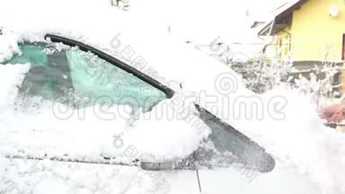 一<strong>位</strong>年轻女子在大雪纷飞后，在汽车<strong>挡</strong>风玻璃上擦雪擦冰