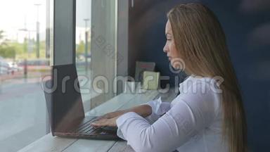 漂亮的女商人用笔记本电脑坐在办公桌前