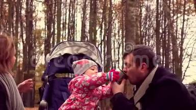 可爱的小女孩和她的父母在<strong>秋天</strong>公园喝着热气腾腾的茶。 家庭野餐。 4Ksteatam<strong>视频</strong>