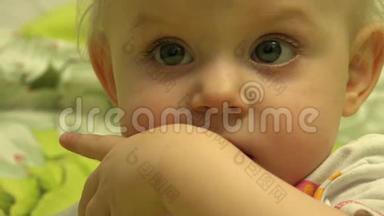 令人惊讶的婴儿咀嚼和咬她是手指。 特写镜头。 4K超高清，超高清