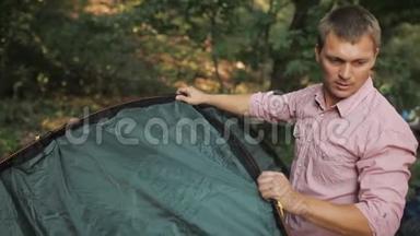 年轻夫妇在树林里搭帐篷