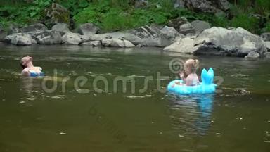 妈妈和女儿在河里。 一个年轻漂亮的女人正和她的小女儿一起在山河里洗澡。 他们是